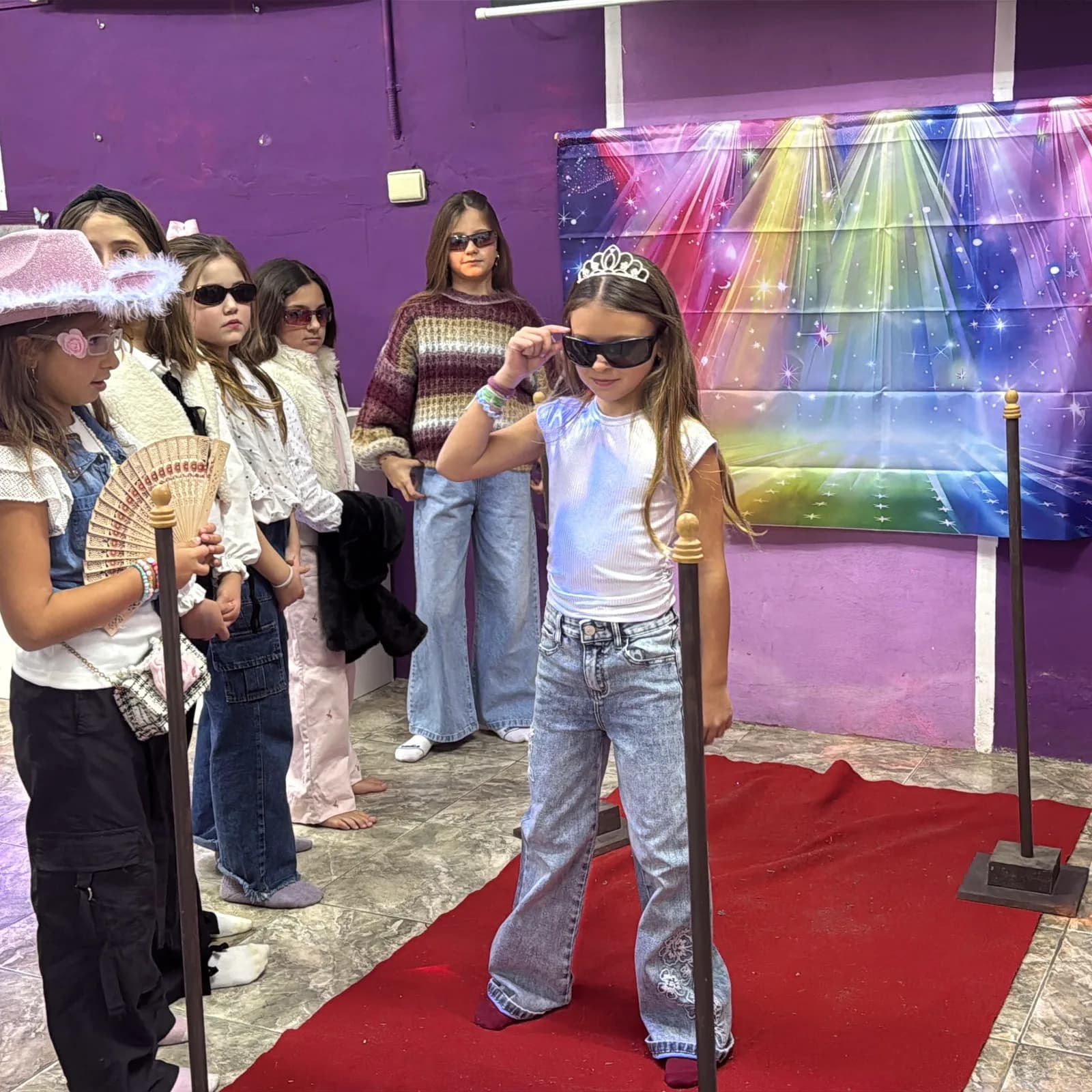 Nena caminando la alfombra roja con tiara y anteojos de sol en la Academia de Estrellas de Rugidos